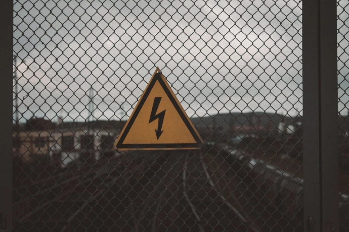 a yellow sign on a fence
